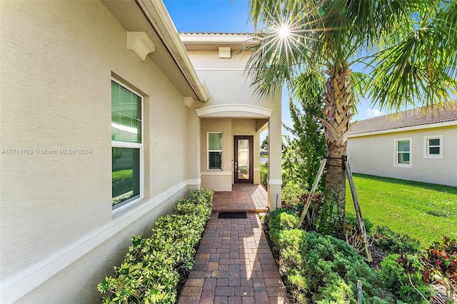 property entrance featuring a lawn