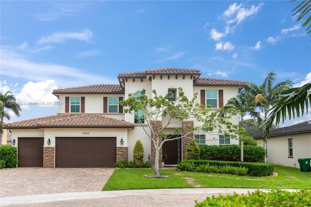 mediterranean / spanish-style home featuring a front yard and a garage