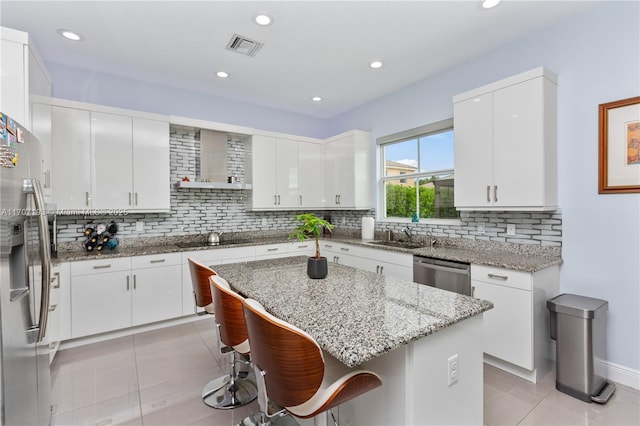 10410 Ranchette Dr, Cooper City, FL 33328 - kitchen featuring appliances with stainless steel finishes, light tile patterned floors, a kitchen breakfast bar, decorative backsplash, and white cabinets