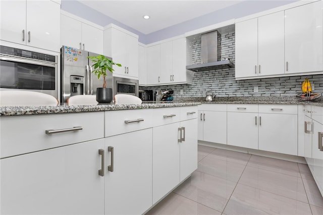 10410 Ranchette Dr, Cooper City, FL 33328 - kitchen featuring stainless steel appliances, wall chimney exhaust hood, light stone counters, white cabinets, and recessed lighting