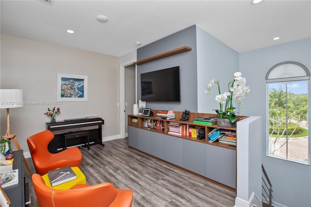 interior space with a textured ceiling, light wood-type flooring, and a healthy amount of sunlight