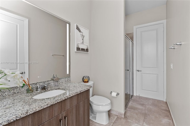 bathroom featuring tile patterned flooring, vanity, an enclosed shower, and toilet