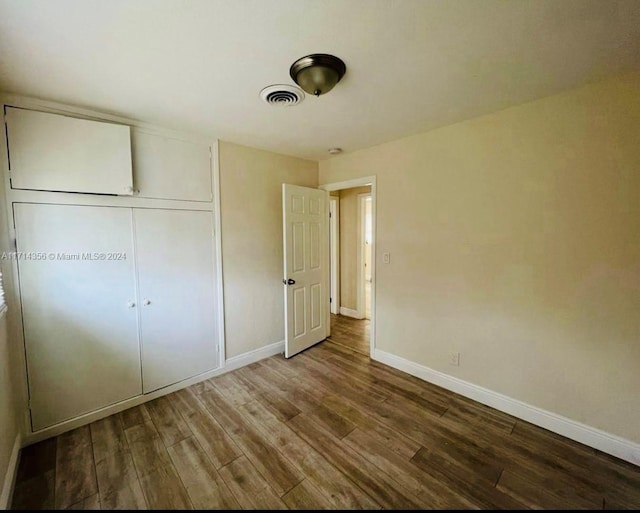 unfurnished bedroom featuring hardwood / wood-style flooring and a closet