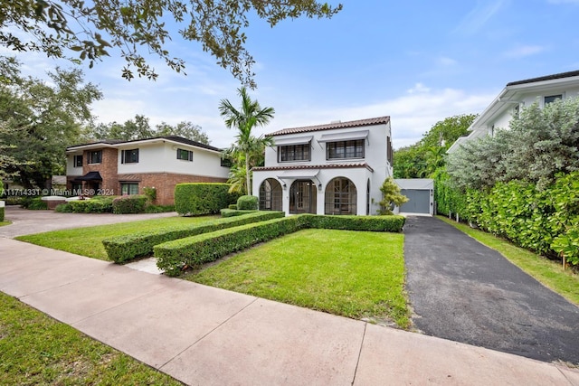 mediterranean / spanish home featuring a front lawn