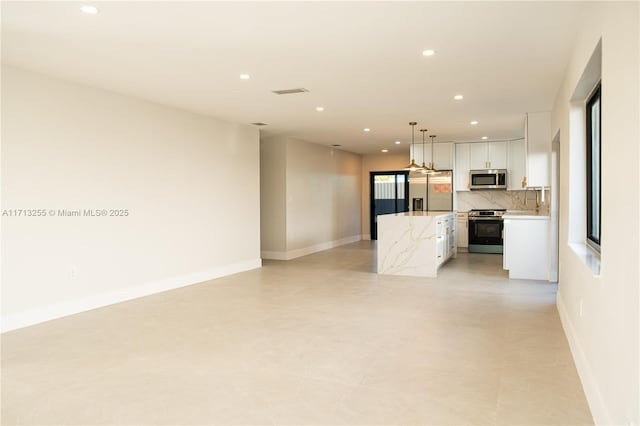 kitchen featuring a center island, stainless steel appliances, pendant lighting, decorative backsplash, and white cabinets