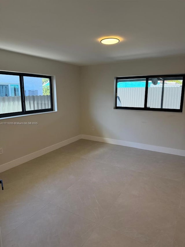 tiled spare room featuring a wealth of natural light