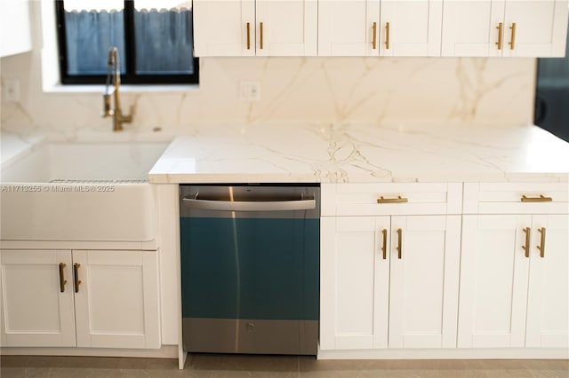 kitchen featuring white cabinetry, light stone counters, and stainless steel dishwasher