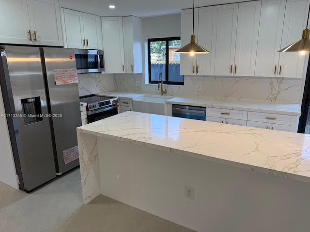 kitchen with light stone countertops, sink, stainless steel appliances, decorative light fixtures, and white cabinets