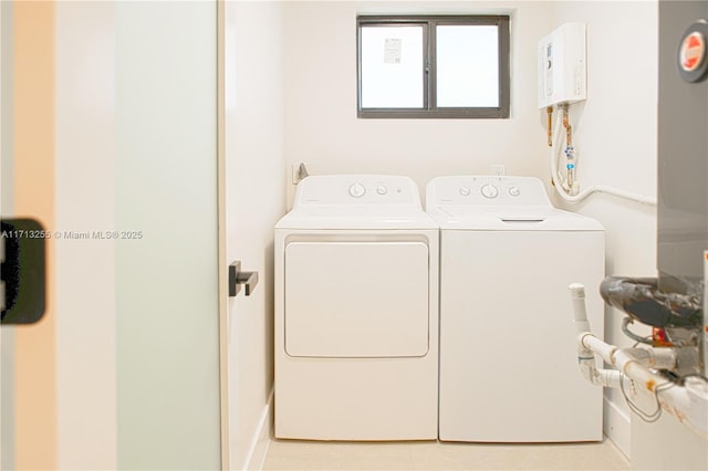 clothes washing area featuring washer and clothes dryer and light tile patterned flooring