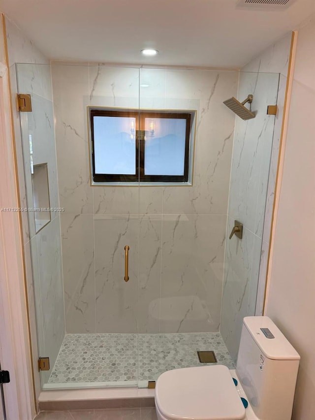 bathroom featuring tile patterned floors, toilet, and an enclosed shower