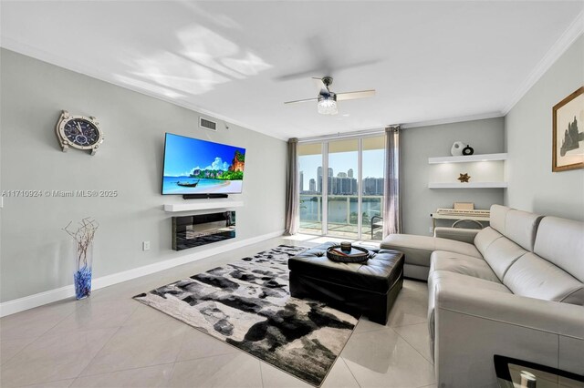 living room featuring ceiling fan, crown molding, light tile patterned floors, and a wall of windows