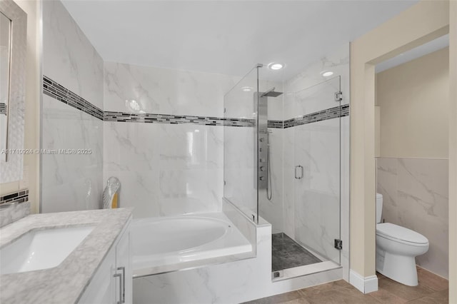 full bathroom with vanity, toilet, tile walls, and separate shower and tub