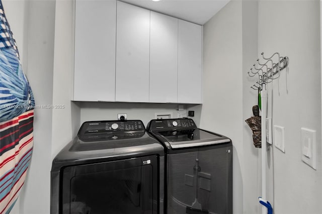 laundry area with cabinets and washer and clothes dryer