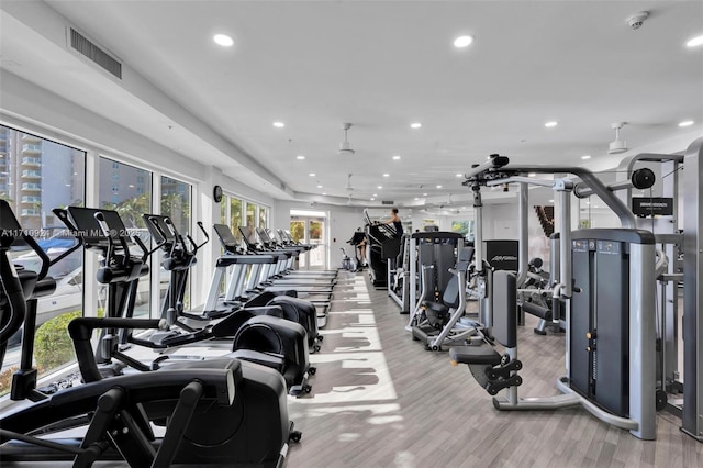 gym featuring light wood-type flooring and ceiling fan