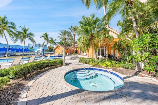 view of swimming pool featuring a patio area and a hot tub