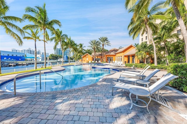 view of swimming pool with a water view and a patio area