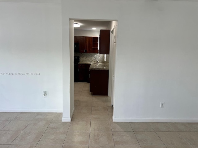 hallway featuring sink and light tile patterned floors