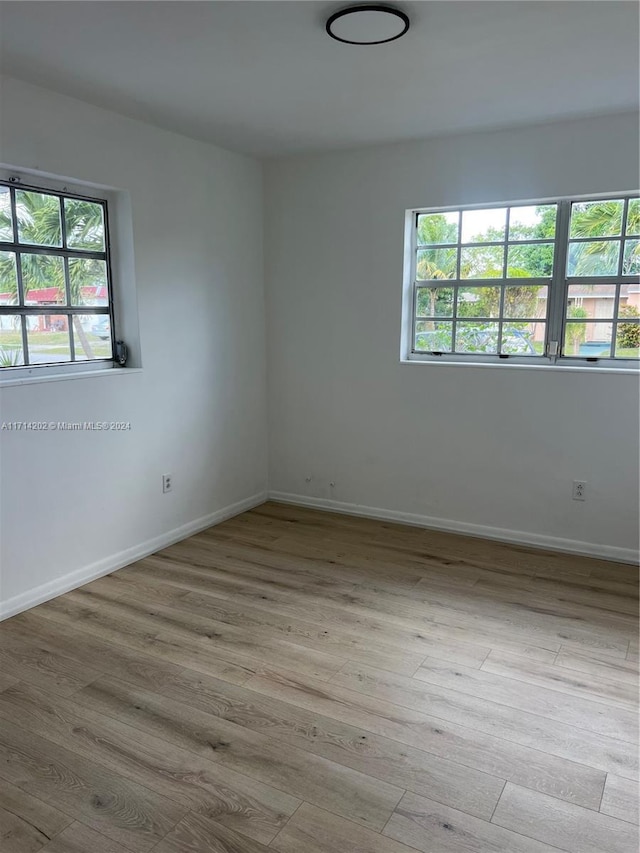 spare room featuring a healthy amount of sunlight and light hardwood / wood-style flooring