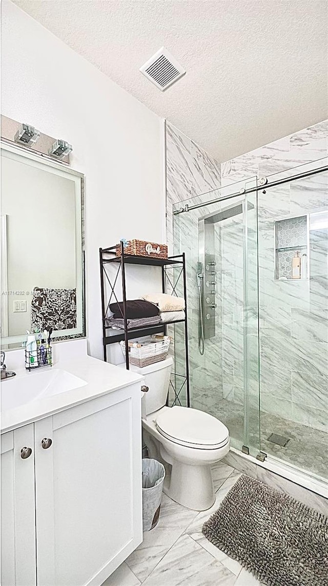 bathroom featuring vanity, a textured ceiling, toilet, and an enclosed shower