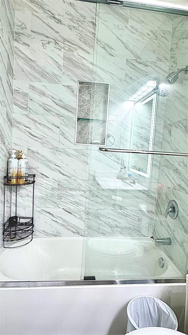 bathroom featuring shower / bath combination with glass door