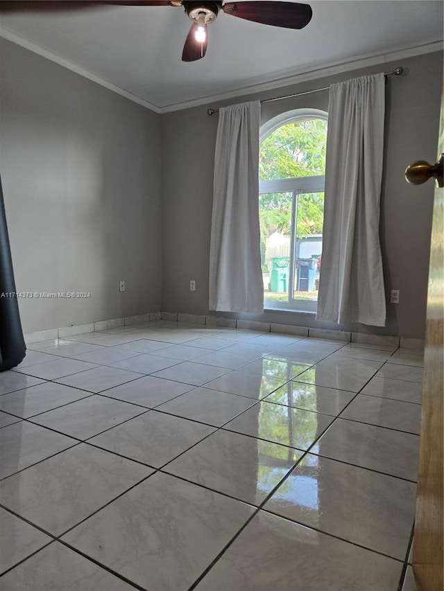 spare room featuring ceiling fan, light tile patterned flooring, and ornamental molding