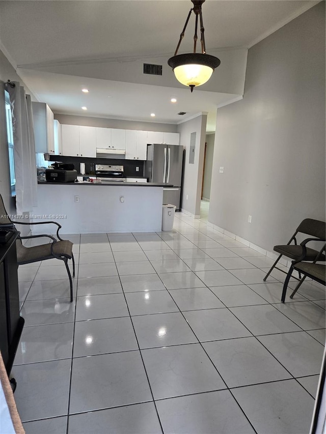 kitchen with hanging light fixtures, white cabinets, lofted ceiling, light tile patterned floors, and appliances with stainless steel finishes