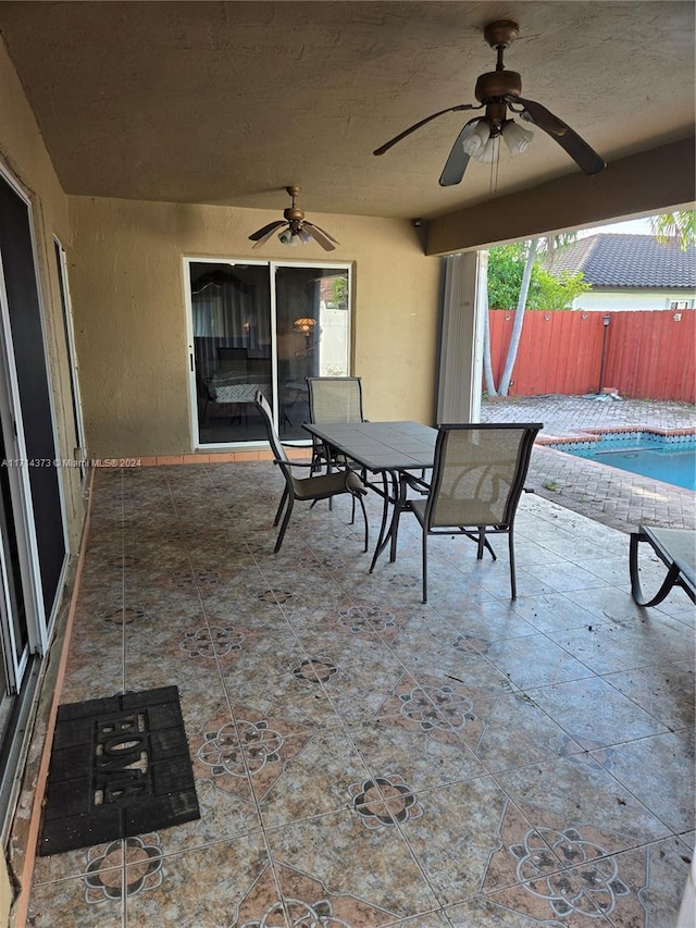 view of patio featuring a fenced in pool and ceiling fan