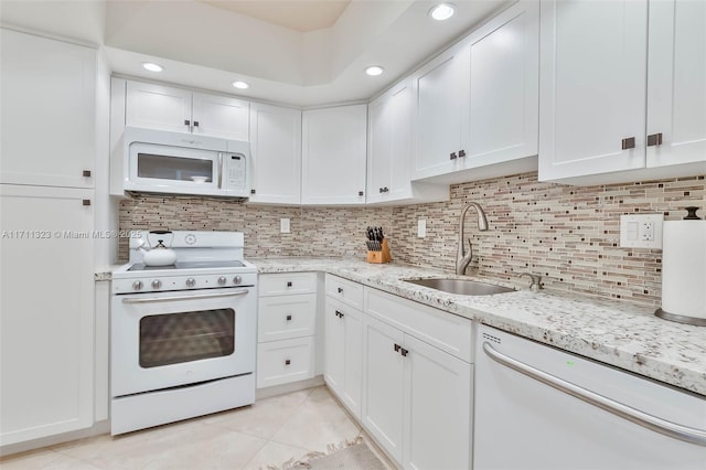 kitchen with sink, tasteful backsplash, light tile patterned floors, white appliances, and white cabinets