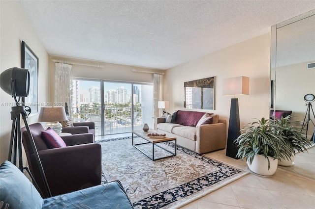 tiled living room featuring a textured ceiling