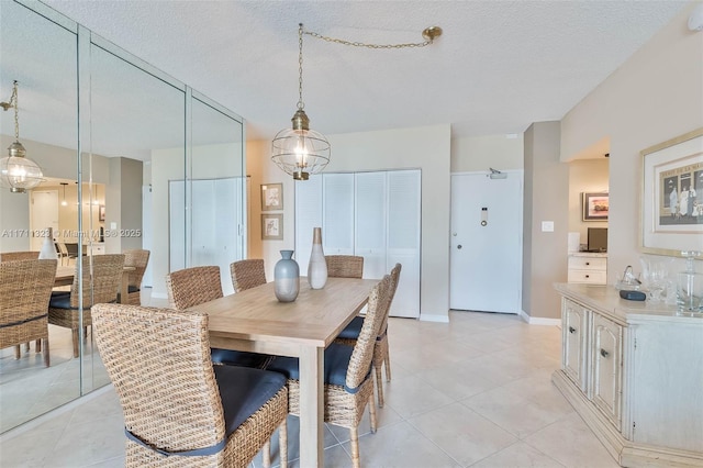 dining space with light tile patterned flooring and a textured ceiling