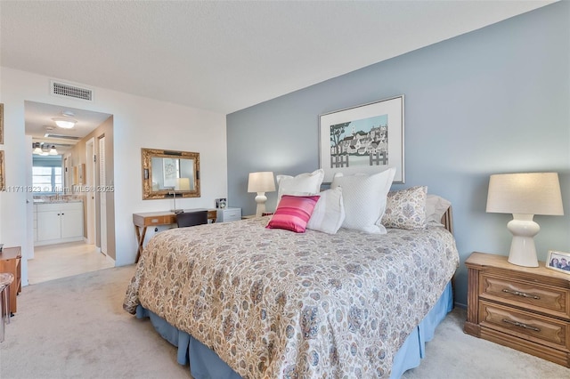 bedroom featuring light carpet and ensuite bathroom