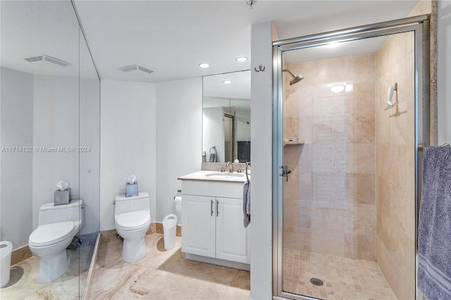 bathroom with vanity, toilet, and a shower with shower door