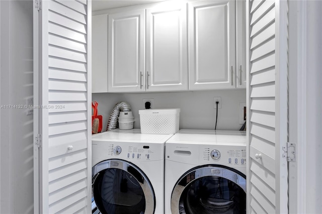 laundry area featuring separate washer and dryer and cabinets