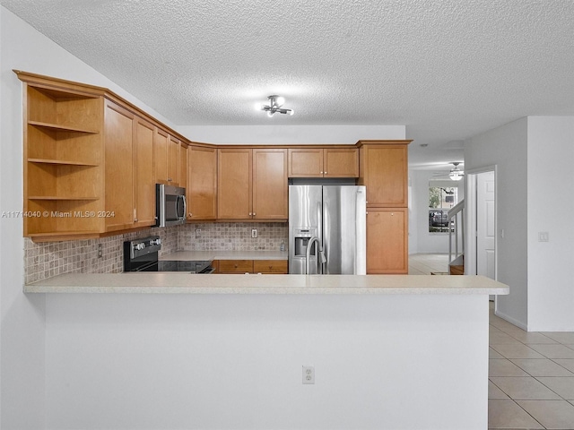 kitchen featuring kitchen peninsula, appliances with stainless steel finishes, tasteful backsplash, and light tile patterned flooring