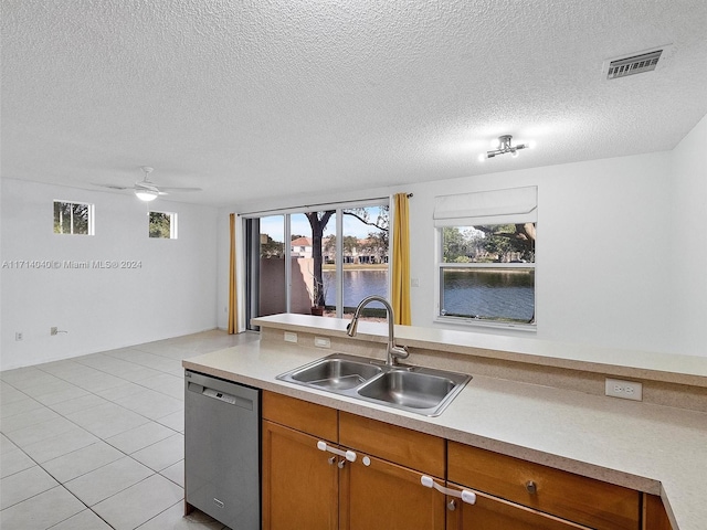 kitchen featuring dishwasher, sink, ceiling fan, a textured ceiling, and light tile patterned flooring