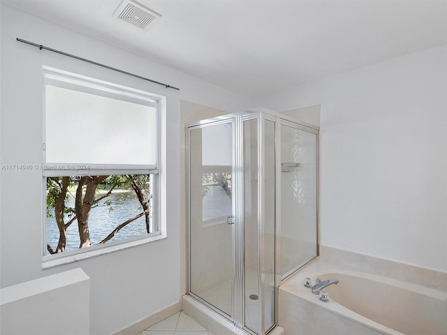 bathroom featuring tile patterned floors, a water view, and shower with separate bathtub