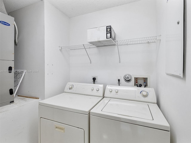 washroom featuring washing machine and dryer and a textured ceiling