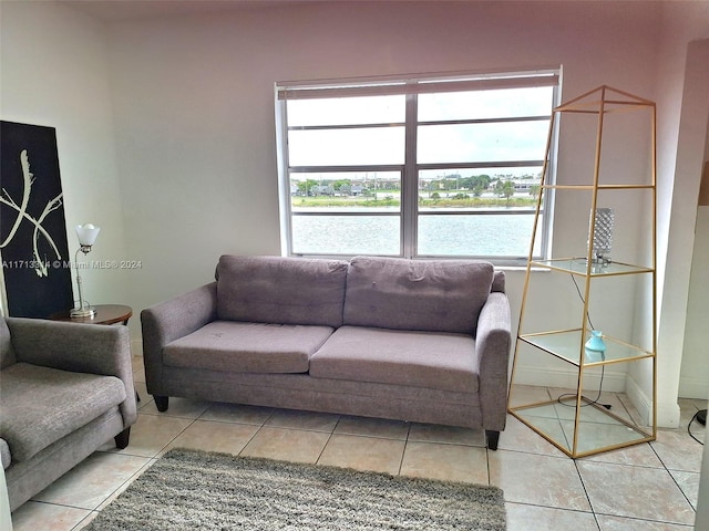 tiled living room featuring a water view