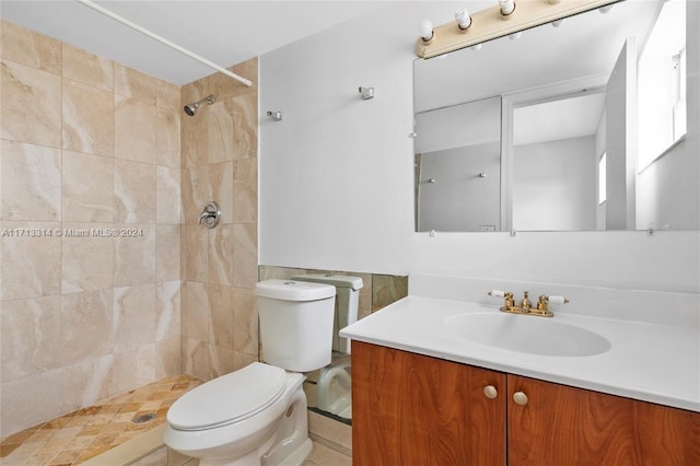 bathroom featuring vanity, toilet, and tiled shower