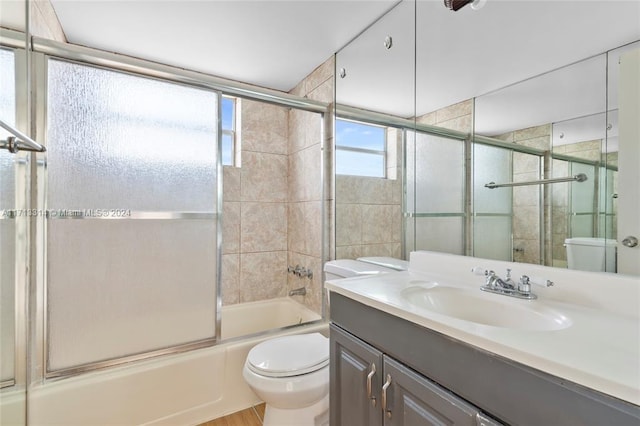 full bathroom with toilet, combined bath / shower with glass door, and vanity