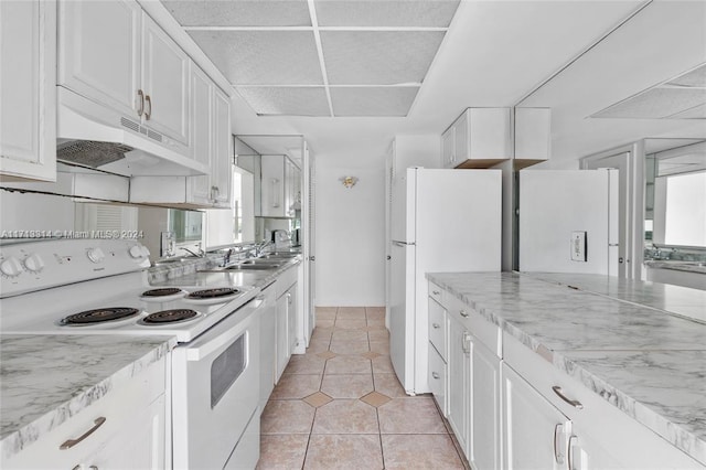 kitchen featuring sink, light tile patterned floors, light stone counters, white appliances, and white cabinets