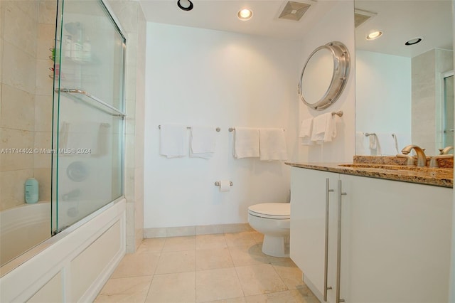 full bathroom featuring tile patterned flooring, combined bath / shower with glass door, toilet, and vanity