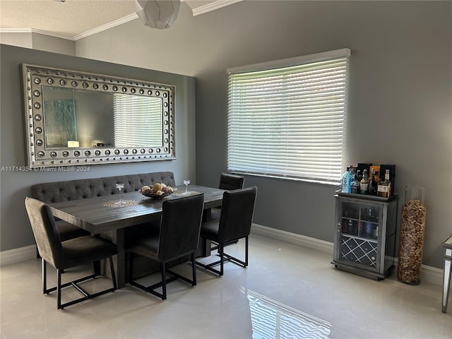 dining space with a textured ceiling, ceiling fan, and ornamental molding