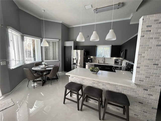 kitchen featuring kitchen peninsula, a textured ceiling, stainless steel appliances, crown molding, and sink