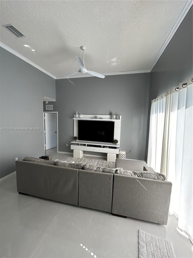 living room with ornamental molding, visible vents, a textured ceiling, and a ceiling fan