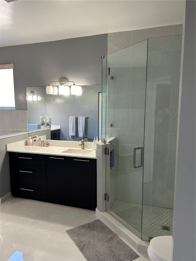 bathroom featuring vanity, an enclosed shower, and toilet