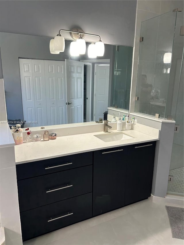 bathroom featuring a closet, a shower stall, and vanity