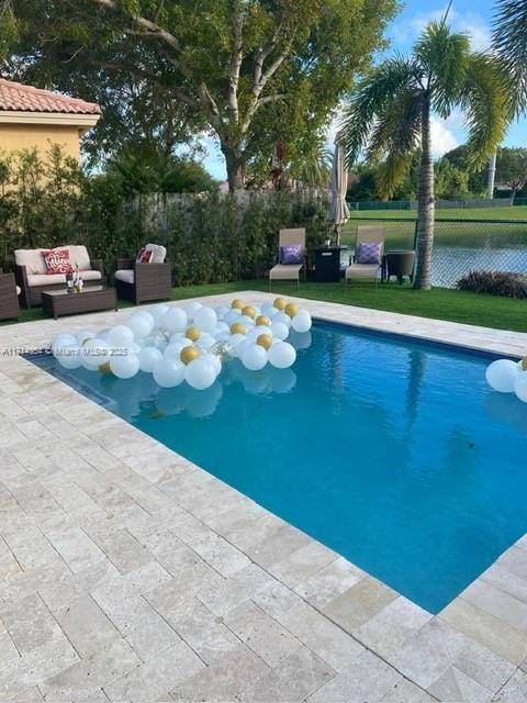 view of pool featuring a patio, outdoor lounge area, fence, and a fenced in pool