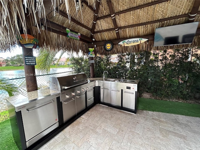 view of patio / terrace featuring an outdoor kitchen, a water view, sink, a gazebo, and area for grilling