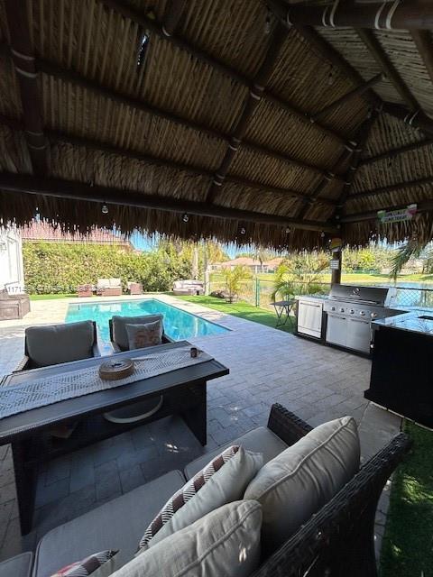 view of patio / terrace featuring exterior kitchen, an outdoor pool, a gazebo, and an outdoor hangout area